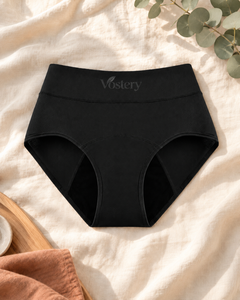Culotte absorbante Vostery taille haute coloris noir posée sur du lin